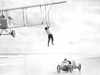 Mabel Cody transfers from car to airplane wing at Daytona Beach in 1921